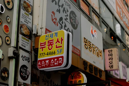 Korean entrepreneur organizing landlord consent form, facade photo, color signboard design and permit application folder | 간판 허가 신고 서류를 폴더별로 정리하는 모습