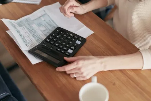 Korean office desk with freelancer invoice, payment ledger, tax calendar marked next month end, realistic editorial photo | 외주비 지급월과 제출기한을 함께 확인하는 장면