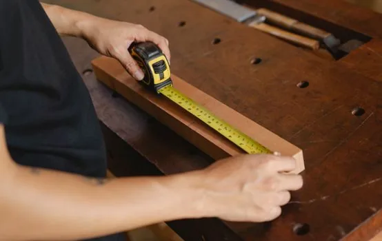 Korean shop owner checking employee rest room size with tape measure and workplace safety checklist