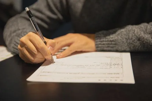 Korean shop tenant checking original commercial lease contract with folder and tax office checklist on cafe table | 상가 임대차계약서 원본과 세무서 제출자료를 확인하는 장면