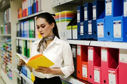 Korean small business owner filing CCTV operation policy, password memo and storage period checklist beside laptop, realistic office documentation photo | CCTV 운영방침과 보관기간 체크리스트를 문서로 정리하는 모습