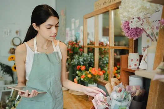 Korean small business owner organizing closure documents on counter