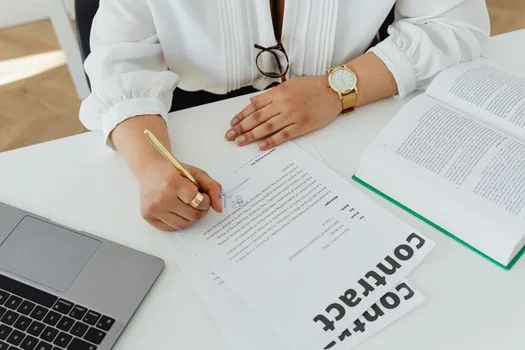 Korean startup desk with employment contract, resident registration copy folder, payroll checklist and laptop, realistic bright office photo | 첫 직원 입사 서류와 신고 전 체크리스트를 대조하는 장면