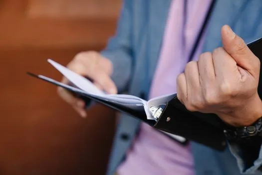 Small business manager organizing employee rest facility inspection notes, work schedule and floor plan