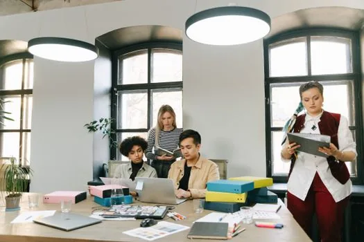 Small company team planning employee training topics, receipts, tax invoice folder and monthly budget spreadsheet | 직원교육 목적과 정산 증빙을 함께 정리하는 회의 장면