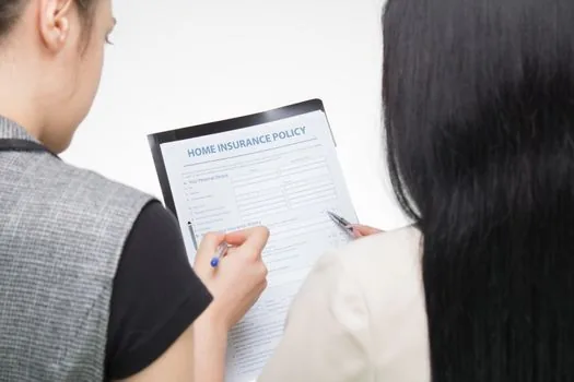small lodging business owner reviewing insurance policy renewal date with calendar and documents, bright office desk, realistic photo | 숙박업소 보험증권과 갱신일을 확인하는 장면