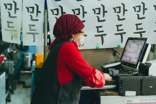 small shop owner cleaning kitchen counter and checking hygiene list before local inspection | 현장실사 전 주방과 위생 점검표를 정리하는 소상공인 매장 장면