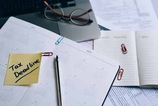 Korean payroll desk with employee files contract forms and retention calendar, realistic bright office photo | 첫 직원 채용 뒤 근로자명부와 근로계약서 파일을 정리하는 장면